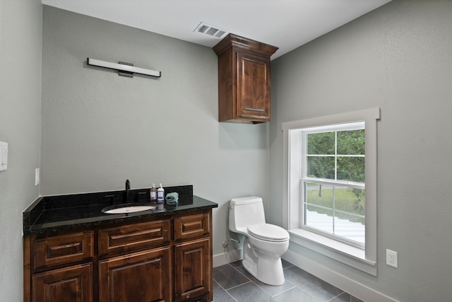 bathroom with tile floors, toilet, and vanity