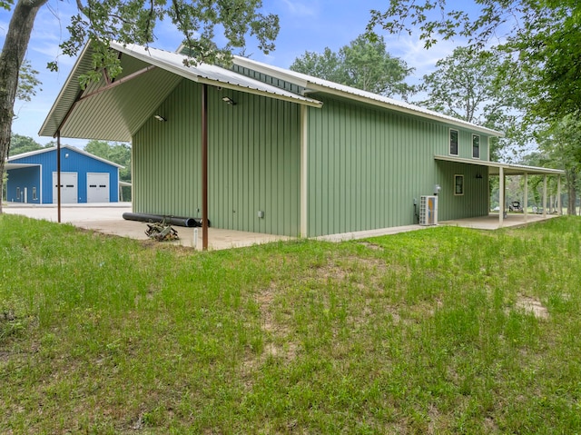 rear view of house with a garage, an outdoor structure, and a yard