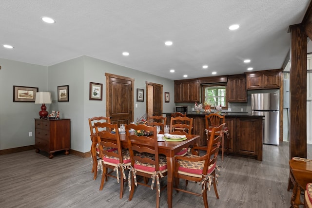 dining area featuring a textured ceiling and wood-type flooring