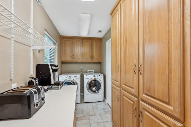 laundry area with separate washer and dryer and cabinets