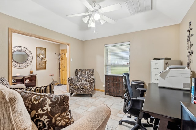 home office featuring a tray ceiling and ceiling fan