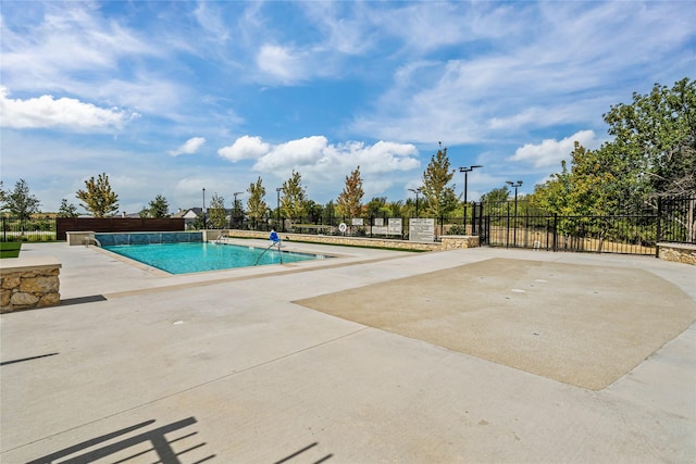 community pool featuring a patio area and fence