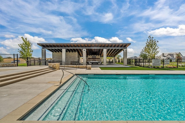 pool with a patio area and fence