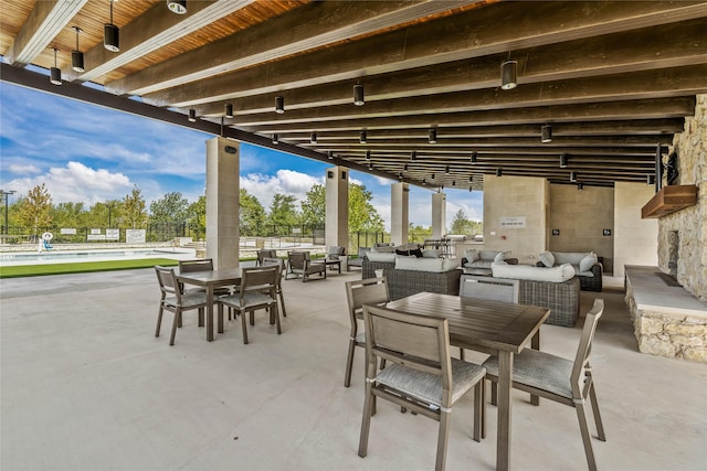 view of patio featuring outdoor dining area, a community pool, and an outdoor living space