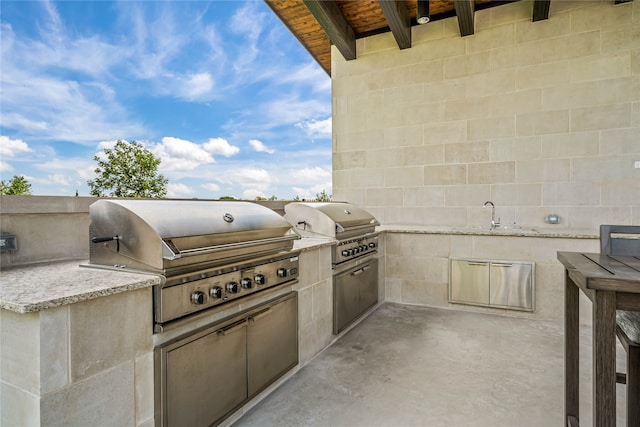 view of patio with grilling area, sink, and an outdoor kitchen