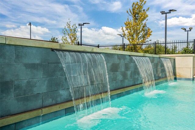 view of pool featuring a lawn and pool water feature