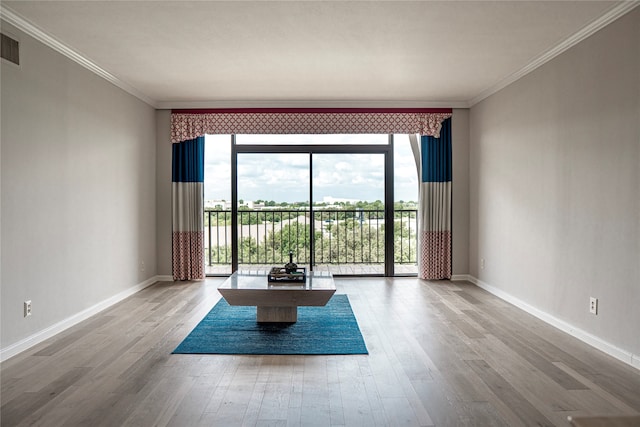 unfurnished room featuring wood-type flooring, a healthy amount of sunlight, and crown molding