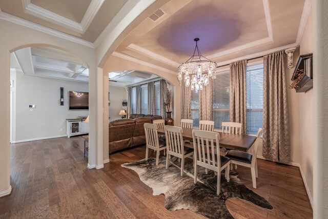 dining room featuring coffered ceiling, dark hardwood / wood-style floors, a chandelier, a tray ceiling, and ornamental molding