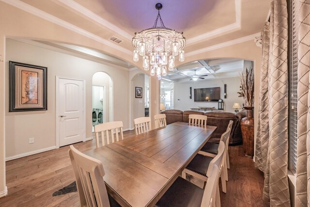 dining room featuring hardwood / wood-style flooring, ceiling fan with notable chandelier, and crown molding