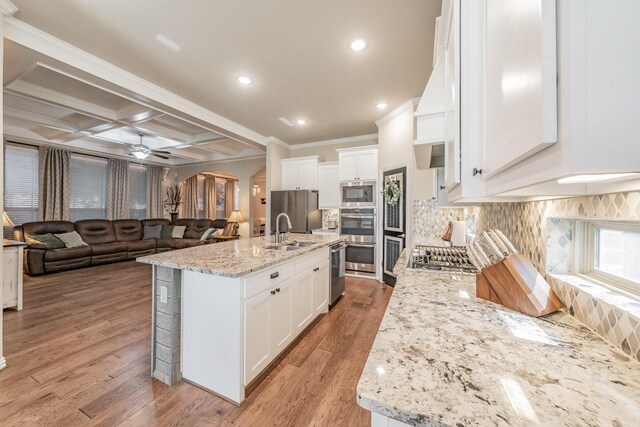 kitchen with white cabinetry, light stone countertops, coffered ceiling, and appliances with stainless steel finishes