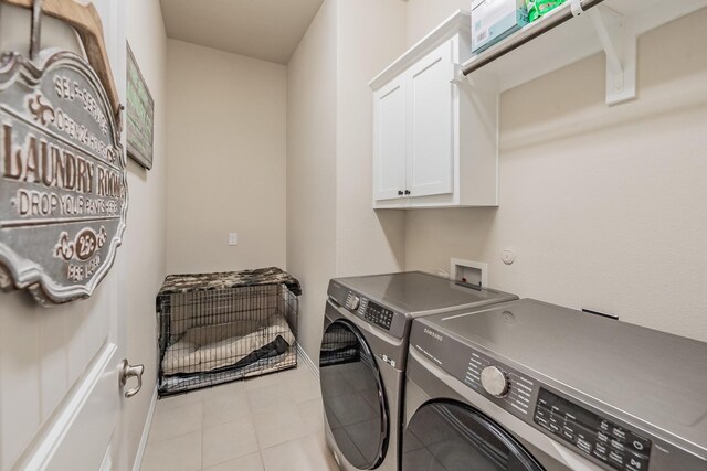 washroom featuring cabinets, light tile patterned flooring, and washing machine and dryer