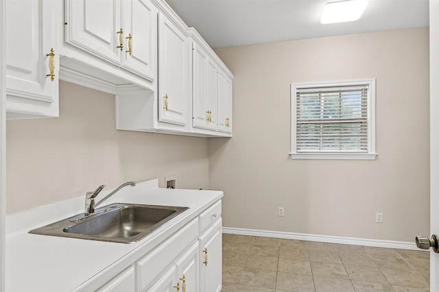 kitchen with sink, white cabinetry, and light tile floors