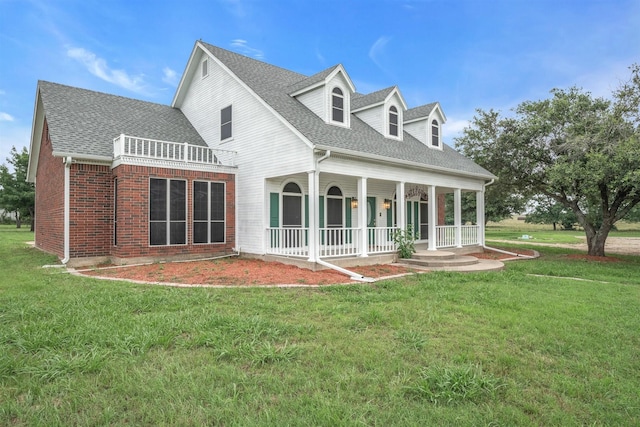 back of house featuring a yard and covered porch