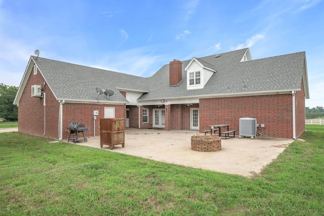 back of property with a patio, central AC, a fire pit, and a yard