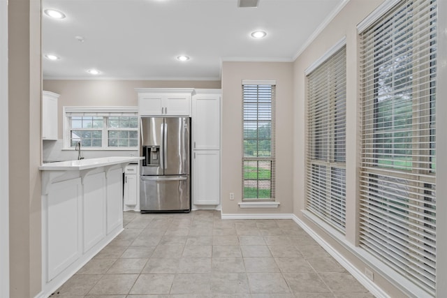 kitchen with crown molding, white cabinets, stainless steel refrigerator with ice dispenser, and light tile floors