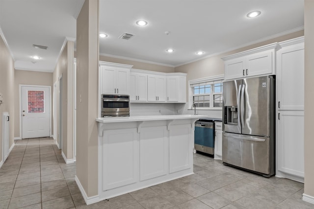 kitchen with appliances with stainless steel finishes, crown molding, white cabinets, and light tile floors