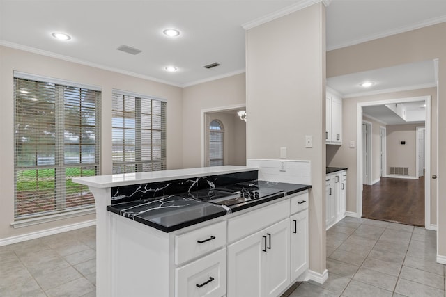 kitchen featuring white cabinetry, ornamental molding, and light tile floors