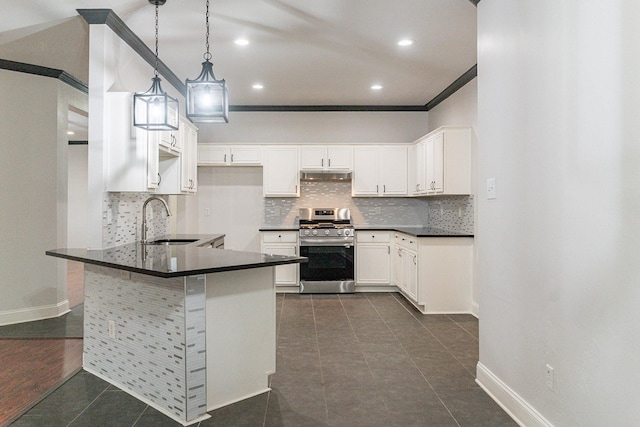 kitchen featuring white cabinetry, sink, hanging light fixtures, tasteful backsplash, and stainless steel gas range oven