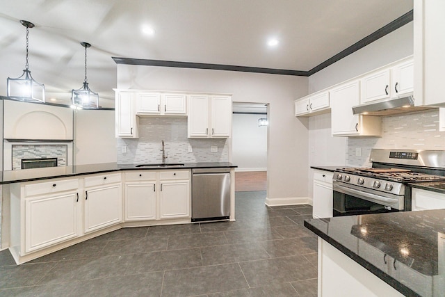 kitchen featuring sink, stainless steel appliances, dark stone countertops, pendant lighting, and white cabinets