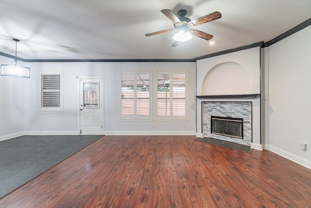 unfurnished living room featuring dark hardwood / wood-style floors, a stone fireplace, and crown molding