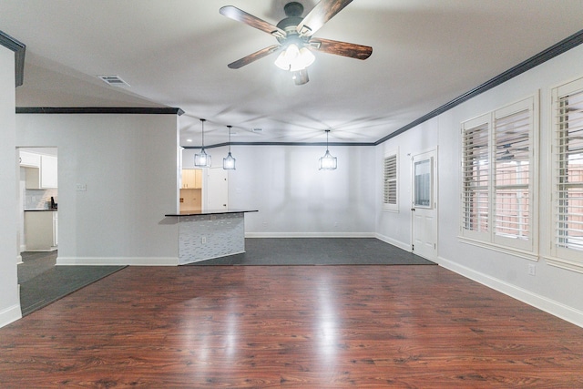 unfurnished living room with ceiling fan, ornamental molding, and dark wood-type flooring