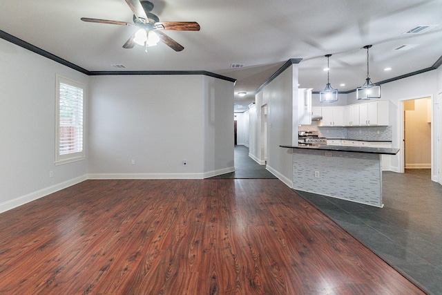 unfurnished living room with dark hardwood / wood-style flooring, ceiling fan, and crown molding