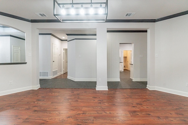 empty room featuring dark hardwood / wood-style flooring and crown molding