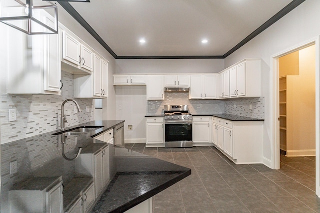 kitchen featuring decorative backsplash, appliances with stainless steel finishes, sink, dark tile patterned flooring, and white cabinets