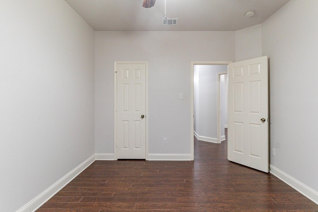 unfurnished bedroom featuring ceiling fan and dark hardwood / wood-style flooring