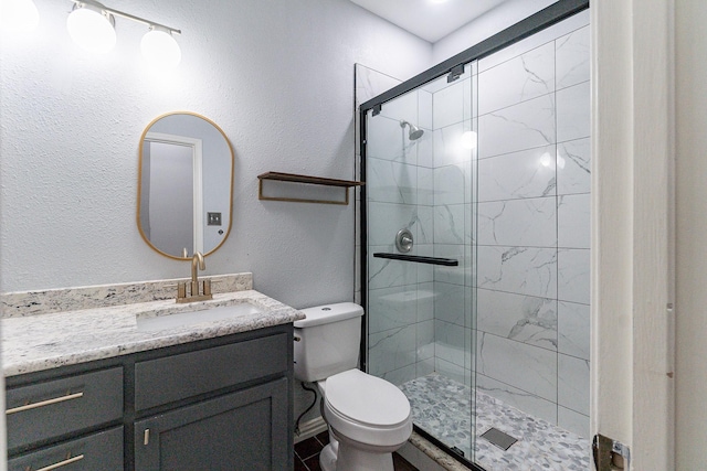 bathroom with an enclosed shower, vanity, and toilet