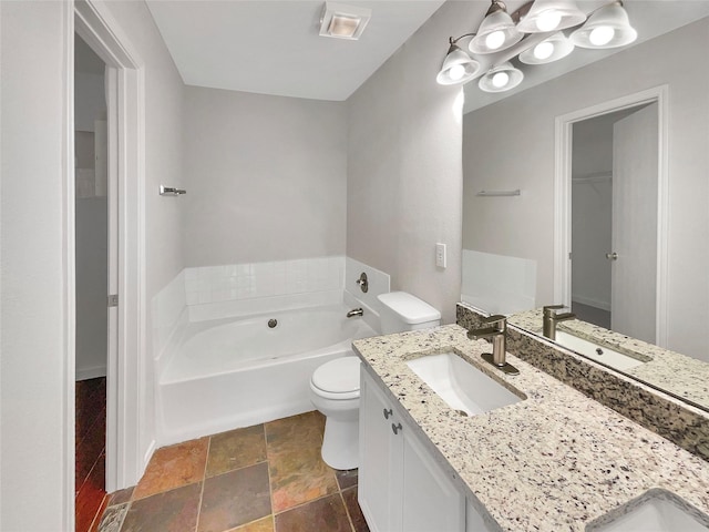 bathroom featuring toilet, vanity, and a bathtub