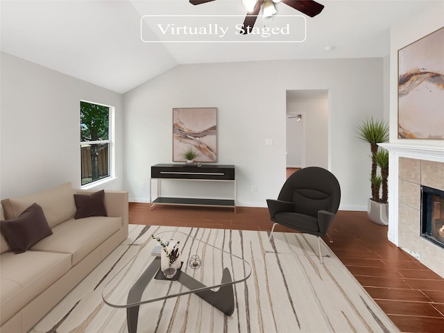 living room featuring vaulted ceiling, ceiling fan, and a fireplace