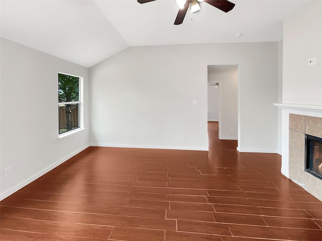 unfurnished living room with ceiling fan, a tile fireplace, dark hardwood / wood-style flooring, and vaulted ceiling