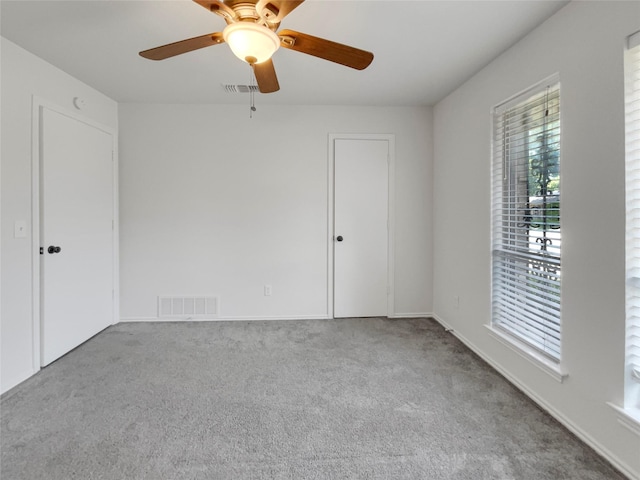 unfurnished room with light colored carpet and ceiling fan