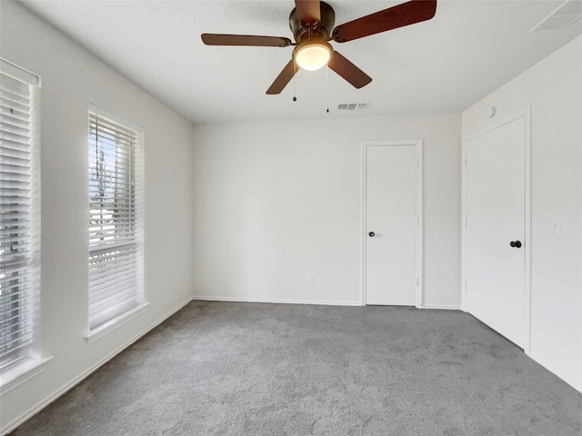 spare room featuring ceiling fan and carpet floors