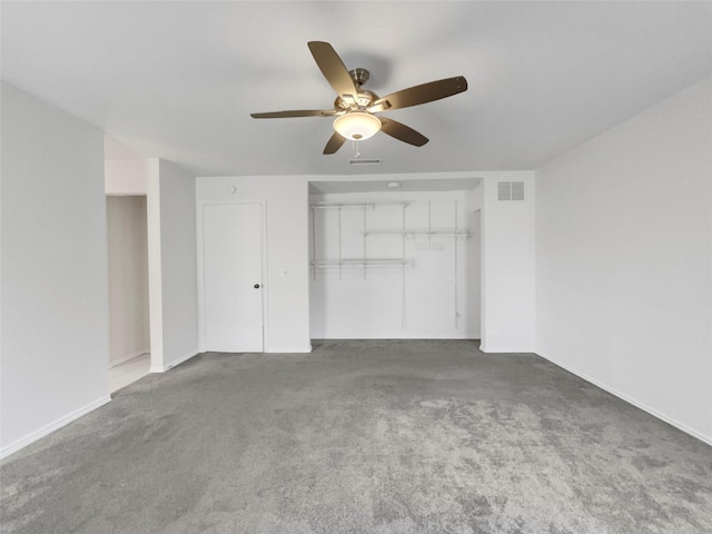 unfurnished bedroom featuring ceiling fan, dark carpet, and a closet