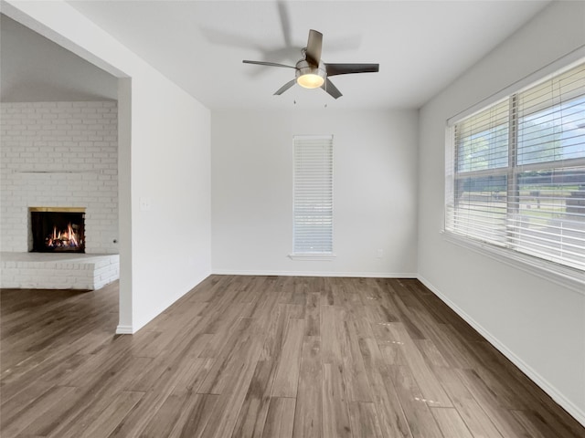 interior space with a fireplace, light wood-type flooring, and ceiling fan