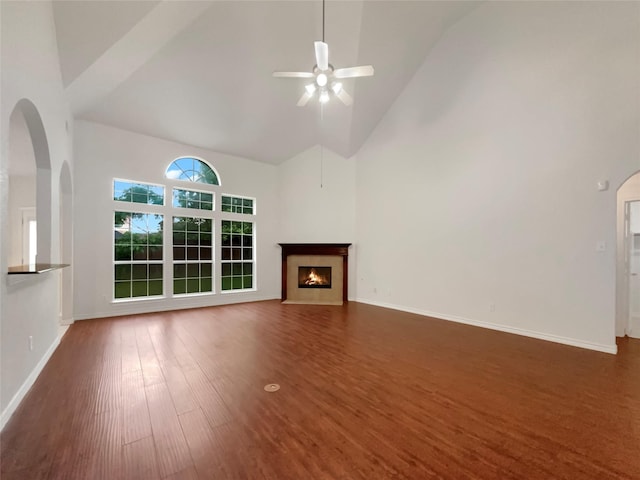 unfurnished living room with ceiling fan, dark hardwood / wood-style flooring, and high vaulted ceiling