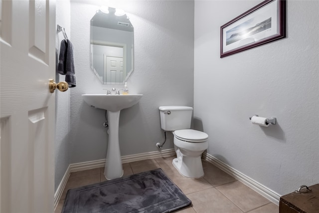 bathroom with sink, toilet, and tile patterned floors