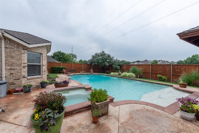 view of swimming pool featuring an in ground hot tub, pool water feature, and a patio area