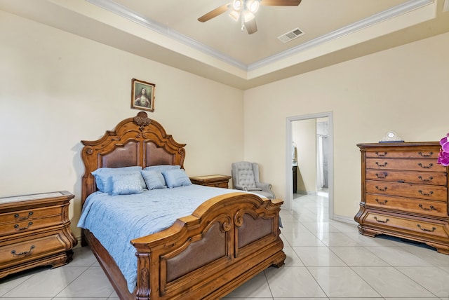 tiled bedroom with a tray ceiling, connected bathroom, crown molding, and ceiling fan