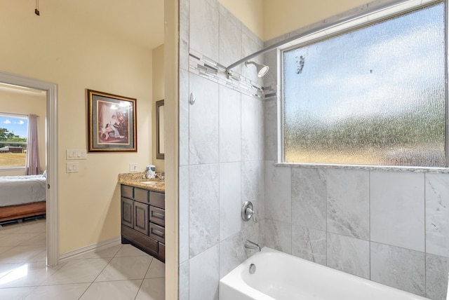 bathroom featuring tiled shower / bath, tile flooring, and vanity