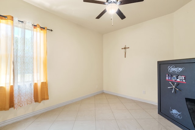 empty room with plenty of natural light, ceiling fan, and light tile floors