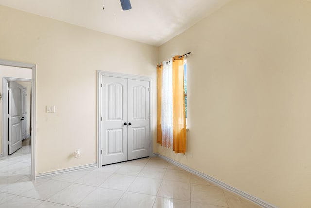 unfurnished bedroom featuring a closet, ceiling fan, and light tile flooring