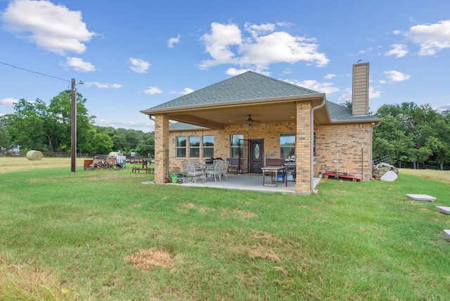 back of house featuring a patio area, ceiling fan, and a lawn