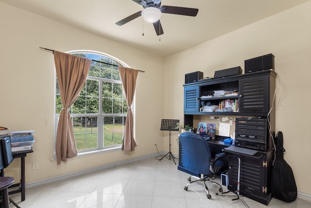 office space featuring a wealth of natural light, ceiling fan, and light tile floors