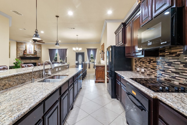 kitchen featuring tasteful backsplash, a fireplace, black appliances, ceiling fan with notable chandelier, and sink