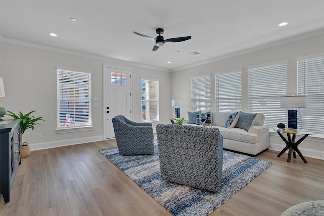 living room featuring hardwood / wood-style floors, ornamental molding, and ceiling fan