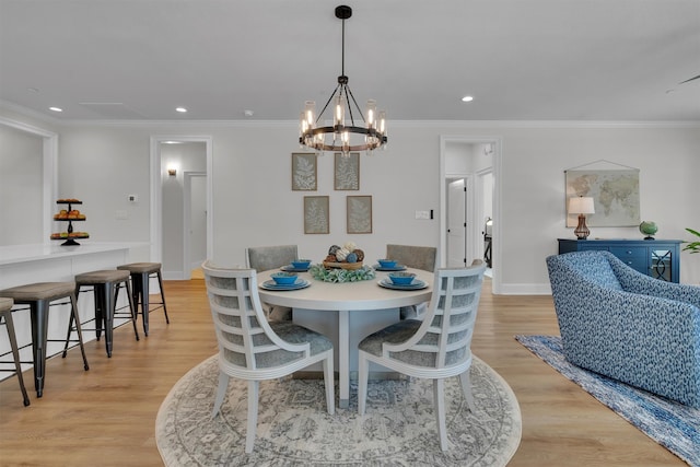 dining space featuring a notable chandelier, light wood-type flooring, and crown molding