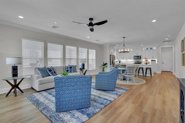 living room with ornamental molding, light hardwood / wood-style flooring, and ceiling fan with notable chandelier